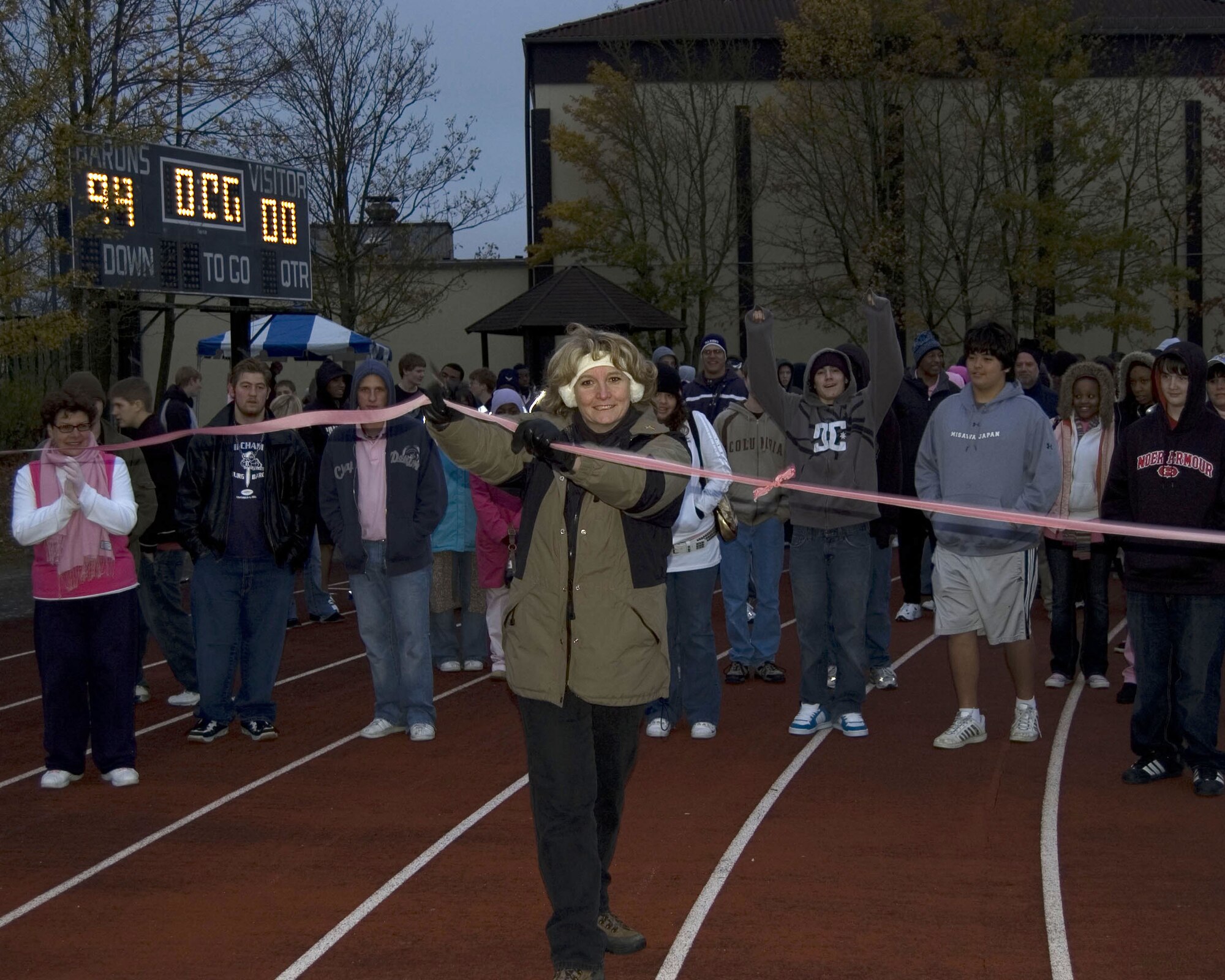Cheryl Roberson, wife of Darryl Roberson, 52nd Fighter Wing commander, cuts the ribbon initiating the Bitburg High School Walk for the Cure event. This event raised awareness about breast cancer and nearly $4,500 for breast cancer research Oct. 25. (U.S. Air Force Photo/Staff Sgt. Chris Mills)