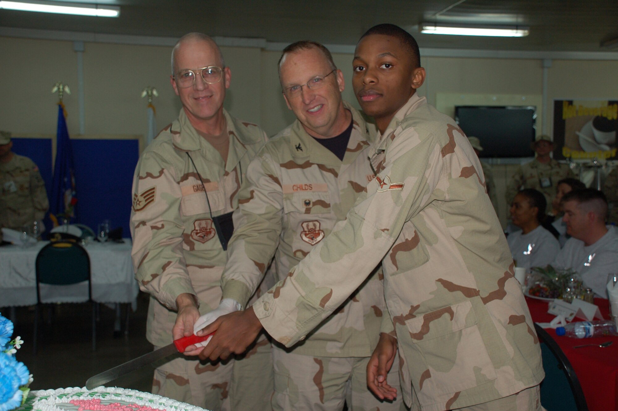 SEYMOUR JOHNSON AIR FORCE BASE, N.C.--Staff Sgt. Glenn Gage (left), a vehicle operations craftsmen, with the 916th Air Refueling Wing, Air Force Reserve, celebrates a birthday he soon won't forget. Sgt. Gage turned 50 while stationed at Manas Air Base, Kyrgyzstan. His deployed military family helped with celebrate a cake and birthday meal at the base dining facility.