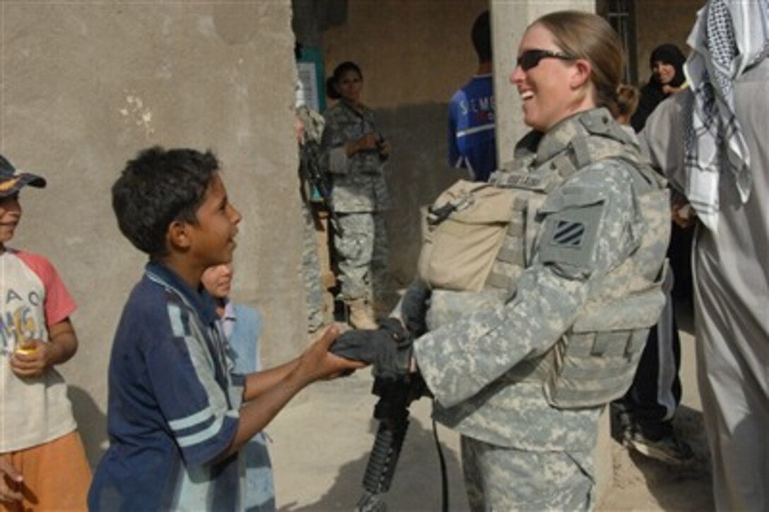 U.S. Army Capt. Trista Mustaine talks with an Iraqi boy during a humanitarian mission in Arab Jabour, Iraq, on Oct. 16, 2007.  Coalition forces provided the local citizens with free medical care and food.  