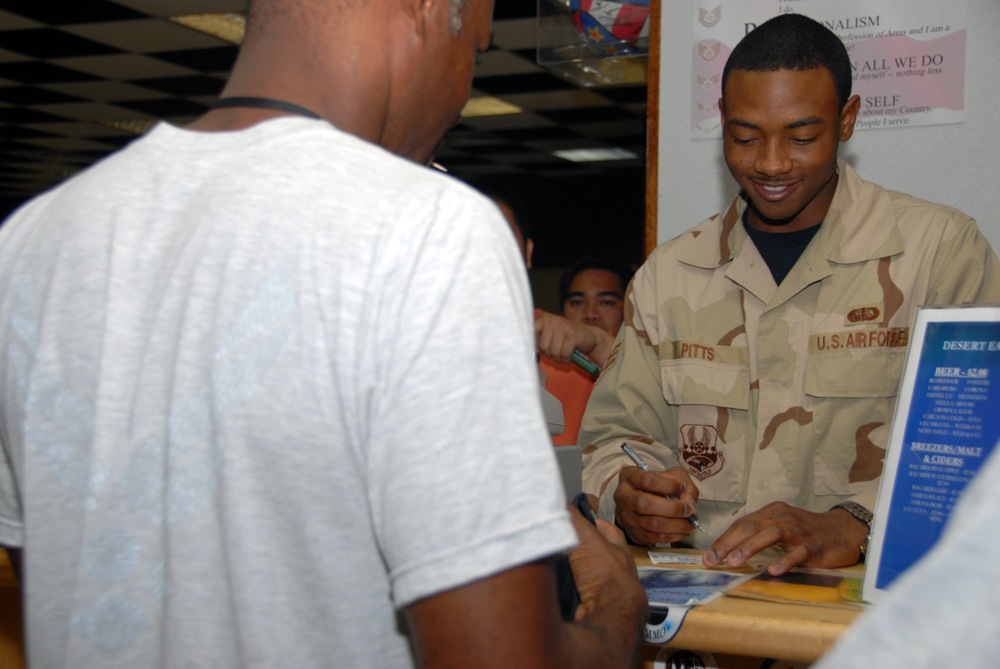 Senior Airman Corey Pitts, 379th Expeditionary Services Squadron, prepares to complete a transaction at the Desert Eagle Lounge. The services squadron offered 16 new college classes this rotation, and saved the Air Force $537,000 in tuition assistance by administering 19 percent of all CLEP exams in Air Combat Command. The 379th Expeditionary Mission Support Group also awarded and executed more than 62 construction projects worth more than $25 million. (U.S. Air Force photo by Airman 1st Class Ashley Tyler)
