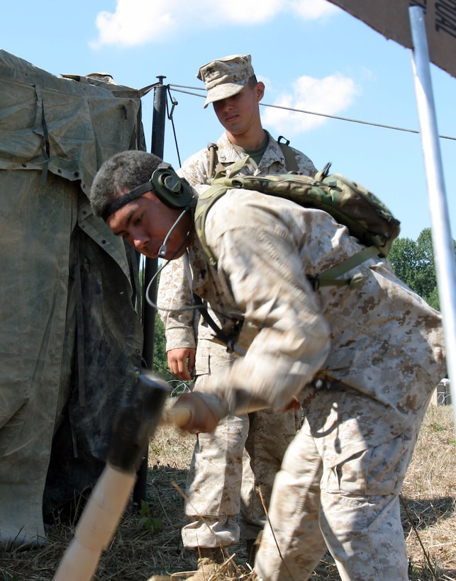 Cpl. Martin Cervantes, admin clerk, Combat Logistics Battalion 24, drives a tent stake into the ground during the setup of a humanitarian assistance campsite on Fort Pickett, Va., Sept. 2. In a matter of hours, the Marines transformed the open field into a secure area able to support 300 refugees. The unit is training for its deployment as the logistical supporting element of the 24th Marine Expeditionary Unit.