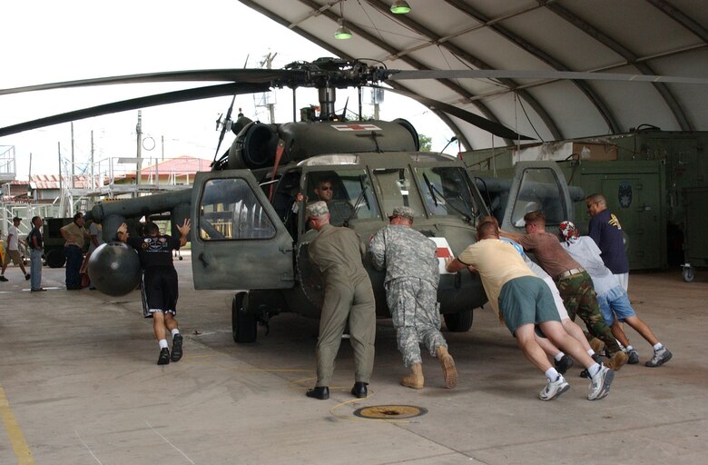 Members of the 1st Batallion, 228th Aviation Regiment move a UH-60 Blackhawk into a hangar at Soto Cano Air Base, Honduras as they prepare for the arrival of Hurricane Felix.  Following the storm the 1-228th will provide transportation for assesment crews from Joint Task Force-Bravo. The purpose of this assessment team is to determine the extent of the damage from the storm and to give planners a better idea of the equipment and personnel needed in the affected countries. U.S. Air Force photo by Senior Airman Shaun Emery.                     