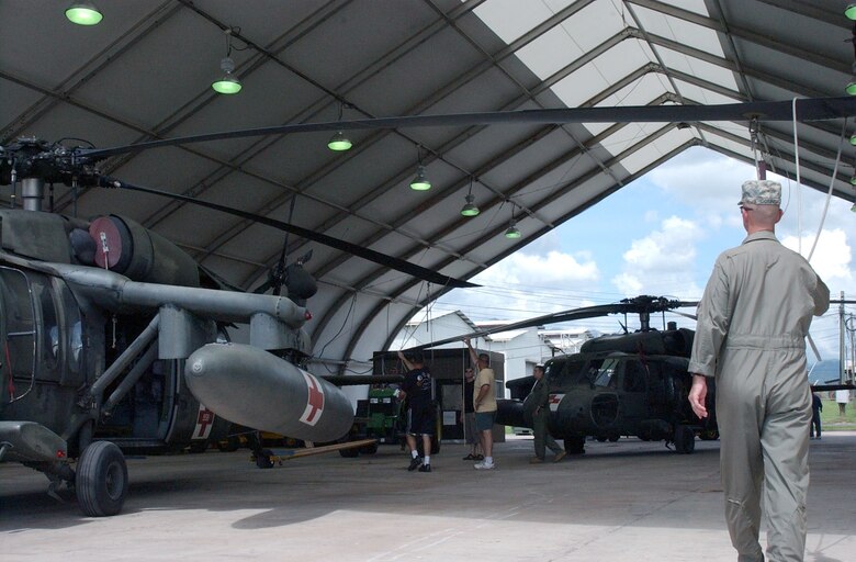 Chief Warrant Officer 4th Class Timothy Connor, a member of the 1st Battalion, 228th Aviation Regiment at Soto Cano Air Base, Honduras, guides the rotor blade of a UH-60 Blackhawk as it is moved off the flightline into a hangar. The 1-228th is taking preparations prior to the landfall of Hurricane Felix. U.S. Air Force photo by Senior Airman Shaun Emery.                            