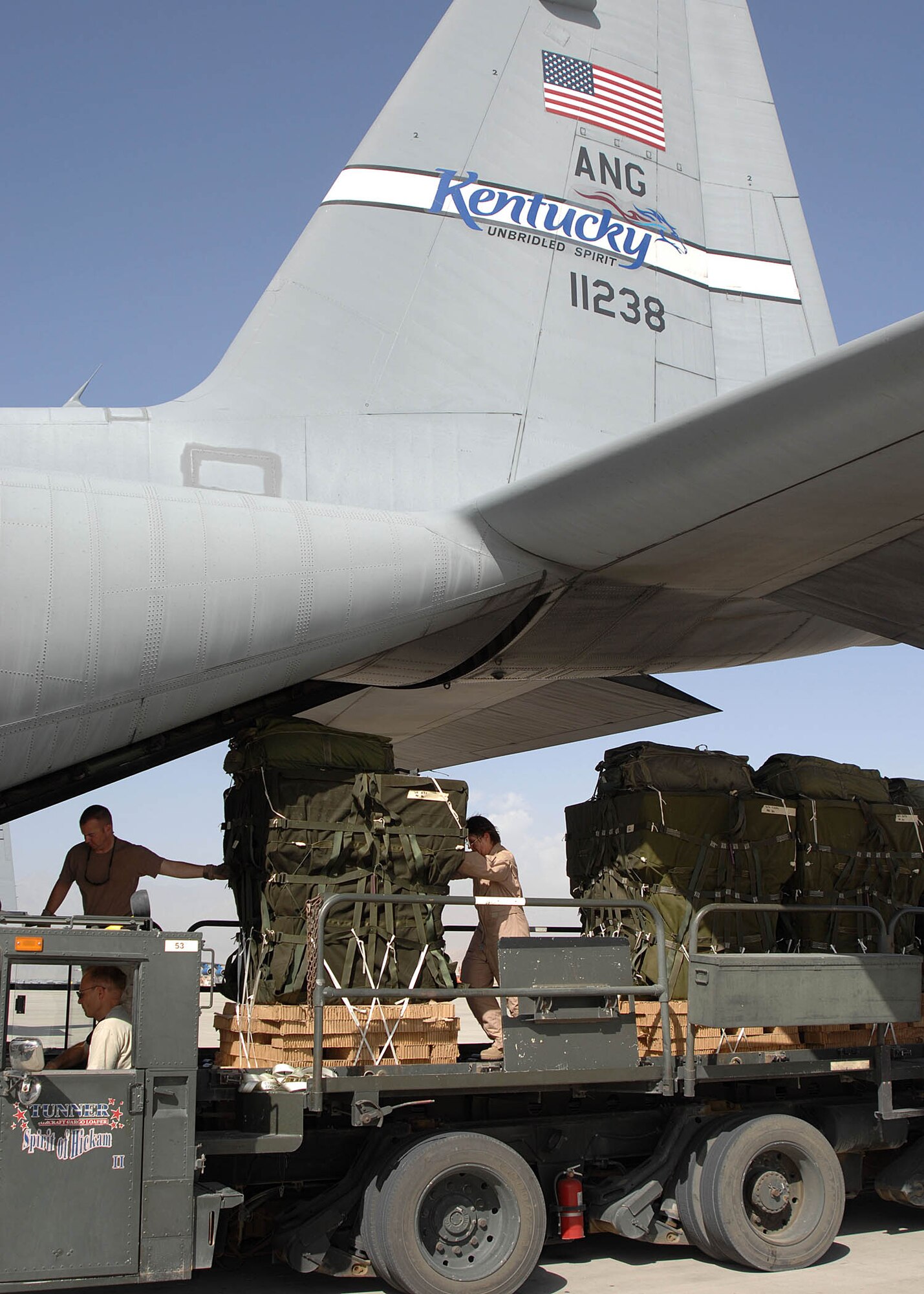 Aircrew members, along with rigging specialists, load airdrop bundles off a K-loader onto a C-130 Hercules transport aircraft on the flightline at Bagram Airfield, Afghanistan. The 774th Expeditionary Airlift Squadron  transported the supplies to troops in the field. (U.S. Air Force photo by Senior Master Sgt. Kim Allain)