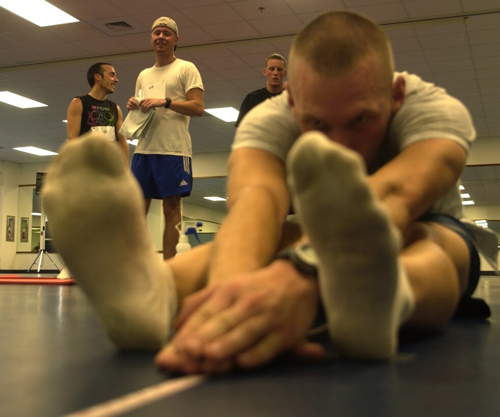 ANDERSEN AIR FORCE BASE, Guam - Senior Airman Bryan Nagy, from the 644th Combat Communications Squadron, demonstrates his flexibility during the sit and reach portion of Andersen's Fitness Challenge Sept. 1 at the fitness center.  Maj. Troy Roberts, 736th SFS, won the sit and reach event. Three five-man teams competed in the challenge.  Individuals were measured in five categories: abdominal circumference, three mile run, sit and reach, push ups and sit ups.  The fitness center staff averaged the scores to determine which team was the overall winner.  The 736th SFS won the fitness challenge.                        