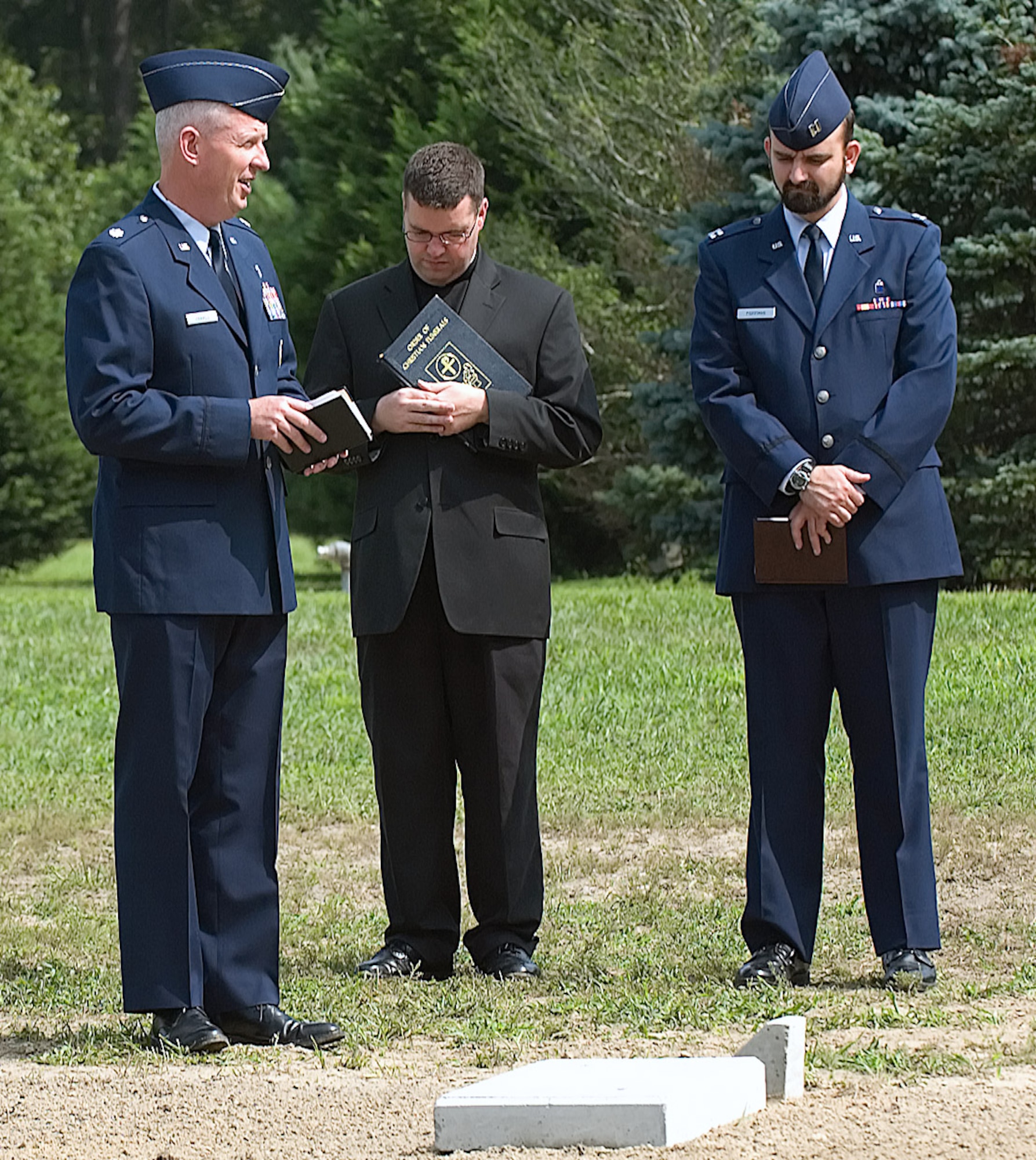 Chaplain (Lt. Col.) Ronald Harvell, Father Michael Darcy and Chaplain (Capt.) Robert Roffman provide Protestant, Jewish and Catholic prayers, respectively, at a ceremony to repatriate 54 deceased Americans Aug. 24 at the Delaware Veterans Memorial Cemetery. Chaplain Harvell is the 436th Airlift Wing chief chaplain, Chaplain Roffman is an individual mobilization augmentee assigned to the 436th AW, and Father Darcy is the assistant pastor of Saint Ann's Catholic Parish, Bethany Beach, Del. (U.S. Air Force photo/Jason Minto)
