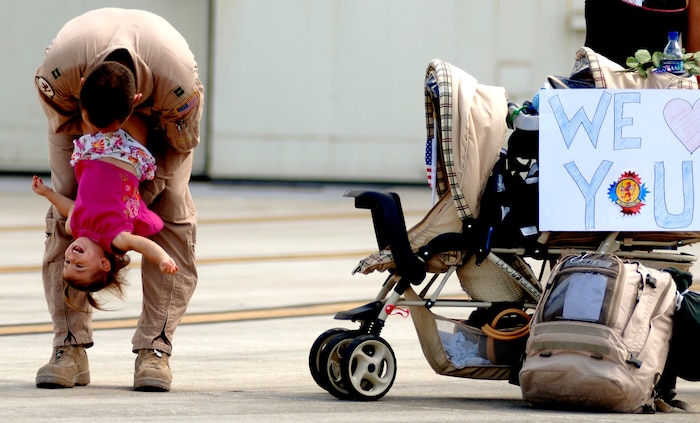 Capt. Zach Hall, 16th Airlift Squadron C-17 pilot, is reunited with his daughter, Sophia, Monday afternoon on Charleston AFB after a four-month deployment to Southwest Asia.  (U.S. Air Force Photo/Airman 1st Class Nicholas Pilch)
