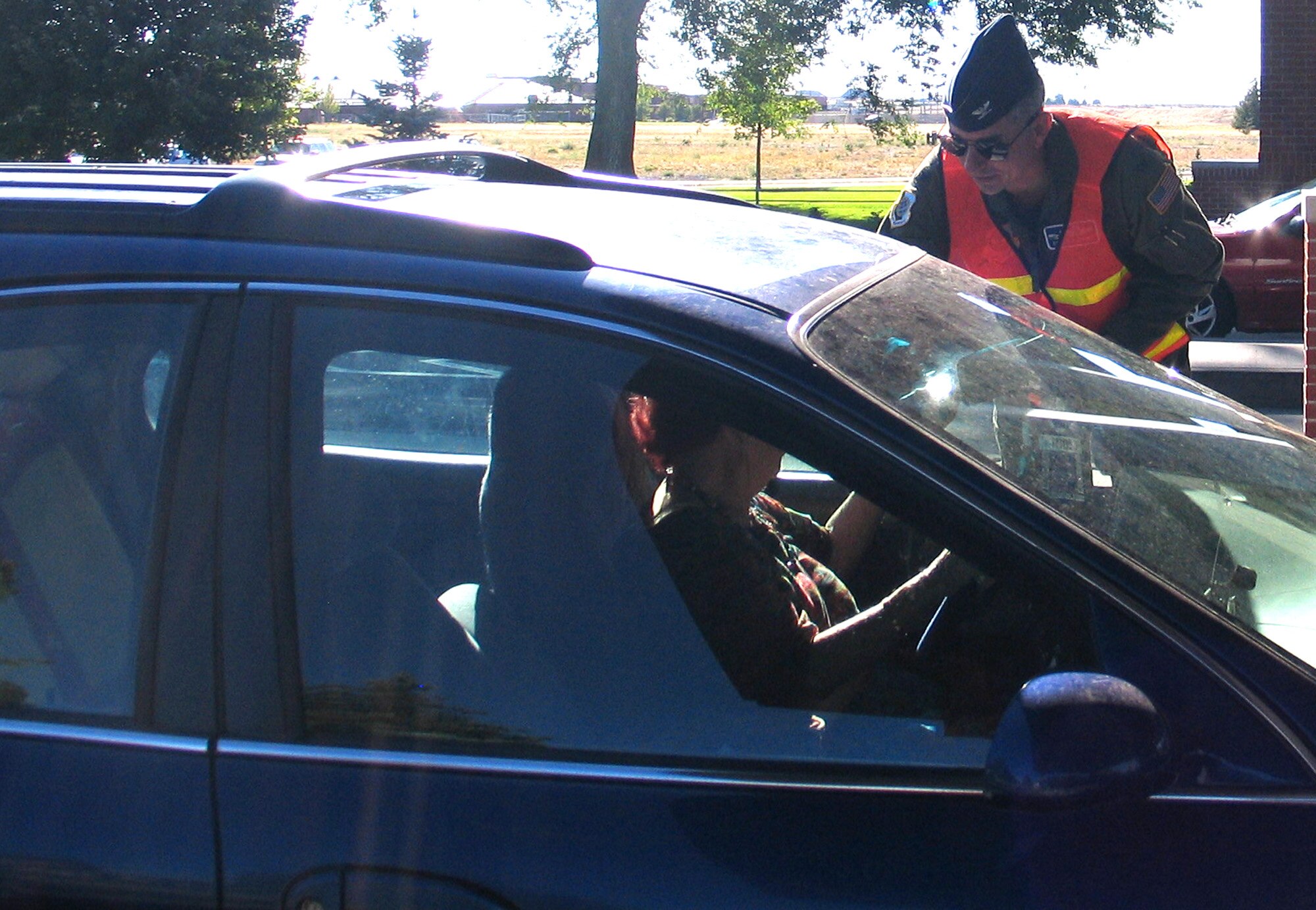 FAIRCHILD AIR FORCE BASE, Wash. – Col. Roger Watkins, 92nd Air Refueling Wing vice commander, greets a driver leaving Fairchild’s main gate with a safety message and bubble gum goody bag Aug. 30. The vice commander was one of about 10 Fairchild leadership figures who helped the wing safety office pass out safety messages before the long Labor Day weekend. (U.S. Air Force photo/Staff Sgt. Connie L. Bias)