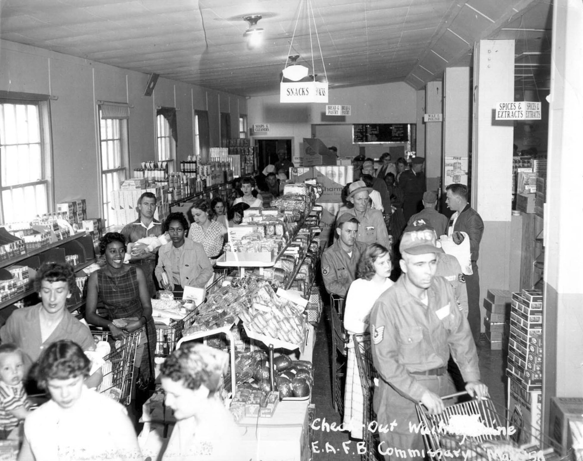 In this 1958 photo, customers line up for checkout at the Ellsworth Air Force Base, S.D., commissary. According to the Defense Commissary Agency, commissaries have come a long way from the days of these narrow aisles. (DeCA historical file) 