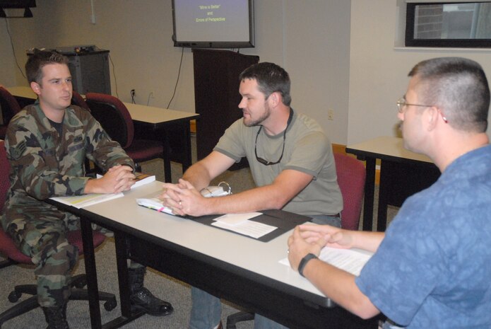 Brent Reinig, education center student, moderates a debate between Staff Sgt. Christopher Cook, 437th Maintenance Operations Squadron Maintenance Operations Center senior controller, and Master Sgt. Marcus Gaines, 437th Airlfit Wing Inspector General superintendent of inspections and readiness, during their current issues in America class Aug. 30 at the base education center. (U.S. Air Force photo/Airman Melissa White)