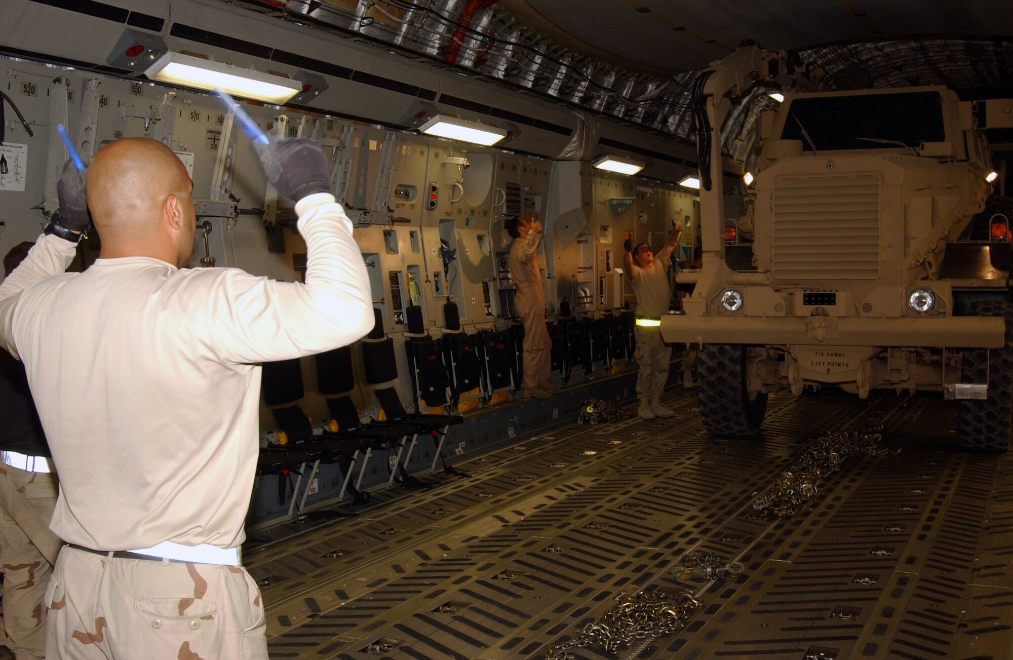 Staff Sgt. Edgar Perez marshals a Mine Resistance Ambush Protected vehicle into a C-17 Globemaster III Aug. 25 at Al Asad Air Base, Iraq. The new MRAP Category III Buffalo model, which weigh about 50,000 pounds each, will phase out the High Mobility Multipurpose Wheeled Vehicles, also known as Humvees. MRAPs are designed to reduce servicemembers' casualties by protecting them from improvised explosive devices, and to increase their mobility and enhance mission success throughout the areas of responsibility. Sergeant Perez is an aerial transportation specialist with 438th Aerial Port Flight deployed from Pope Air Force Base, N.C. (U.S. Air Force photo/Senior Airman Olufemi A. Owolabi) 
