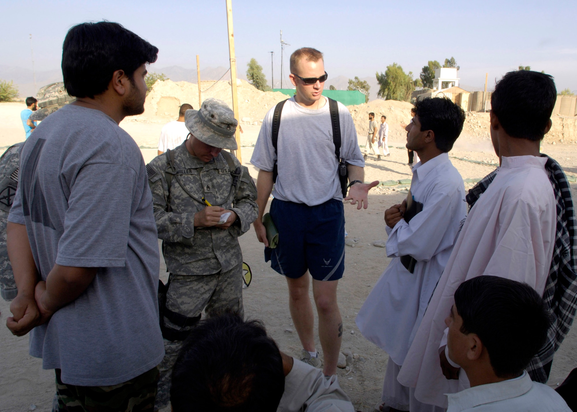 Capt. Matthew Brennan (center) talks with Jahedi, the Afghan director of the Laghman Youth Society about construction projects in the province during a weekly volleyball game hosted by Airmen and Soldiers Aug. 26 at Forward Operating Base Mehtar Lam, located in Afghanistan's Laghman Province. The volleyball games are designed to bring area high school students from the province's five districts, onto the base in order to meet and interact with military members in a friendly atmosphere. Captain Brennan is a Provincial Reconstruction Team member and a civil engineer. (U.S. Air Force photo/Master Sgt. Jim Varhegyi) 
