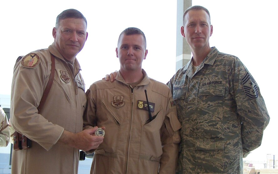 ALI AIR BASE, Iraq -- Senior Airman Robert Russell, deployed 7th Civil Engineer Squadron firefighter, receives a coin from Lt. Gen. Gary North, 9th Air Force and U.S. Central Command Air Forces commander, Aug. 22, after he responded on outside the wire vehicle accidents with the 407th Rescue Air Mobility Squadron. (Photo courtesy of Master Sgt. Timothy Brown)