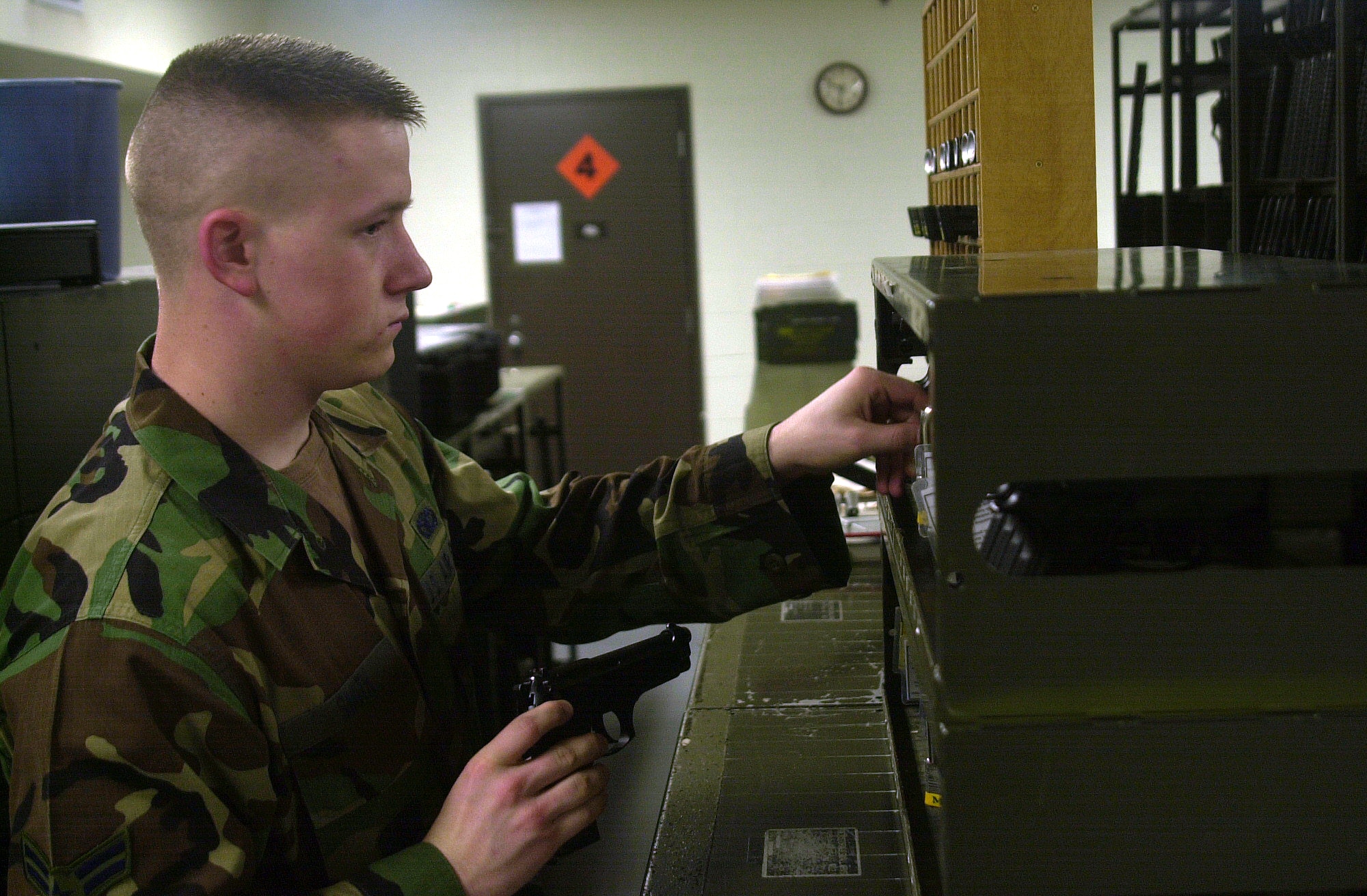 Airman 1st Class Jeremy Smith checks out an M-9 service pistol at the 17 SFS armory Aug. 23. (U.S. Air Force photo by Airman 1st Class Stephen Musal)