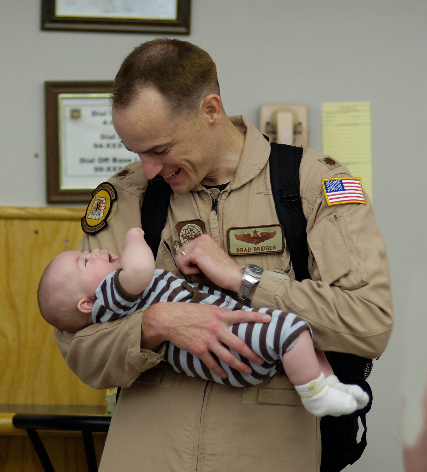 Maj. Brad Bridges, assistant director of operations for the 6th Airlift Squadron, McGuire Air Force Base, N.J., plays with his 3-month-old son, Nick, while waiting to deploy to Southeast Asia with his squadron in support of the Global War on Terrorism. Major Bridges is part of the Air Force's first single-squadron C-17 deployment. Along with members from other McGuire organizations, they will comprise the 816th Expeditionary Airlift Squadron. (U.S. Air Force photo/Kenn Mann)