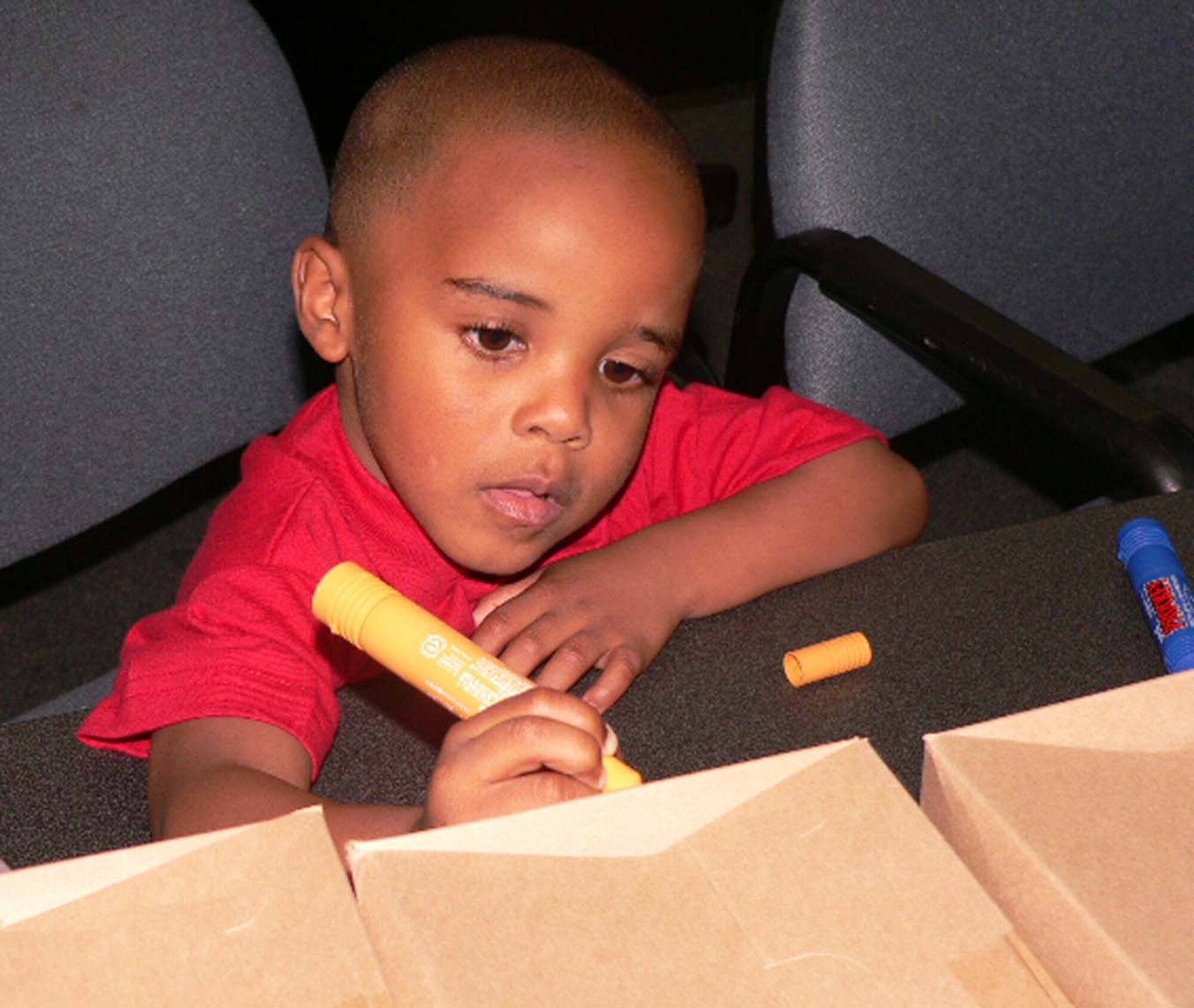 MISAWA AIR BASE, Japan -- Jules Williams, 4, creates a design on the side of a care package Sept. 5 in the 35th Security Forces Squadron conference room. The spouses of deployed SFS Airmen got together to send off care packages for their loved ones. Children decorated the boxes with well wishes with the help of their parents. The squadron Readiness Assistant Volunteer Karen Rinehart organized the evening, which included pizza, chips, soda, water and homemade cupcakes. The families put together more than 50 packages. The evening was also an opportunity for the spouses to meet the squadron commander and first sergeant. Jules is the son of Senior Airman Tyrone and Desiree Nutter. (U.S. Air Force photo by Tech. Sgt. A.C. Eggman)