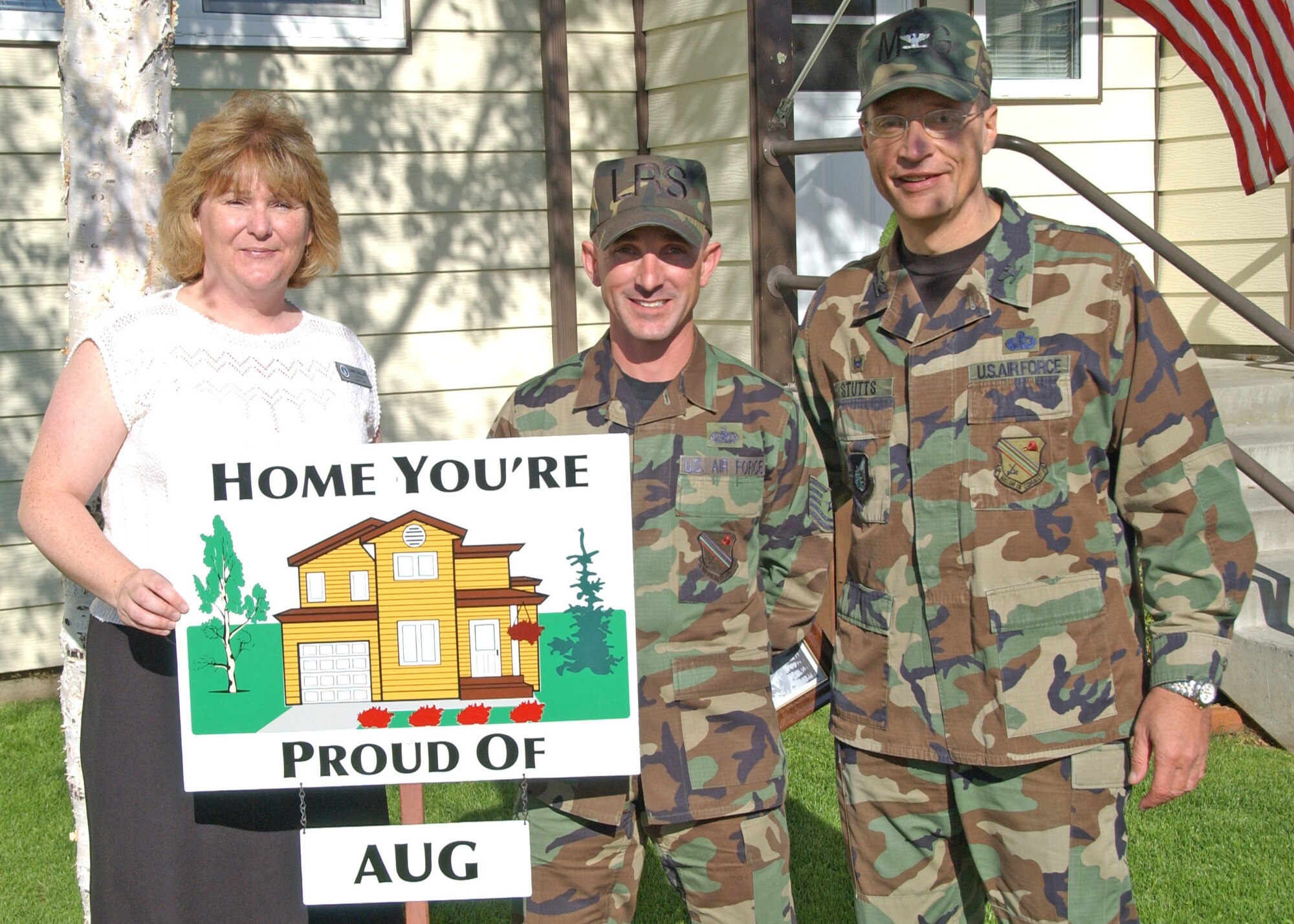 EIELSON AIR FORCE BASE, Alaska--Tech. Sgt. Corey Proulx, 354th Logistics Readiness Squadron, poses for a photo with Col. John Stutts, 354th Mission Support Group commander, and Lorie Dallas, 354th CES military family housing, Sept. 5 during the last Home You're Proud Of recognition for the summer. Sergeant Proulx and his family are the winners for Area 3. HYPO is sponsored by the Eielson Enlisted and Officer's Spouses Club. (U.S. Air Force photo by Airman 1st Class Christopher Griffin)                               