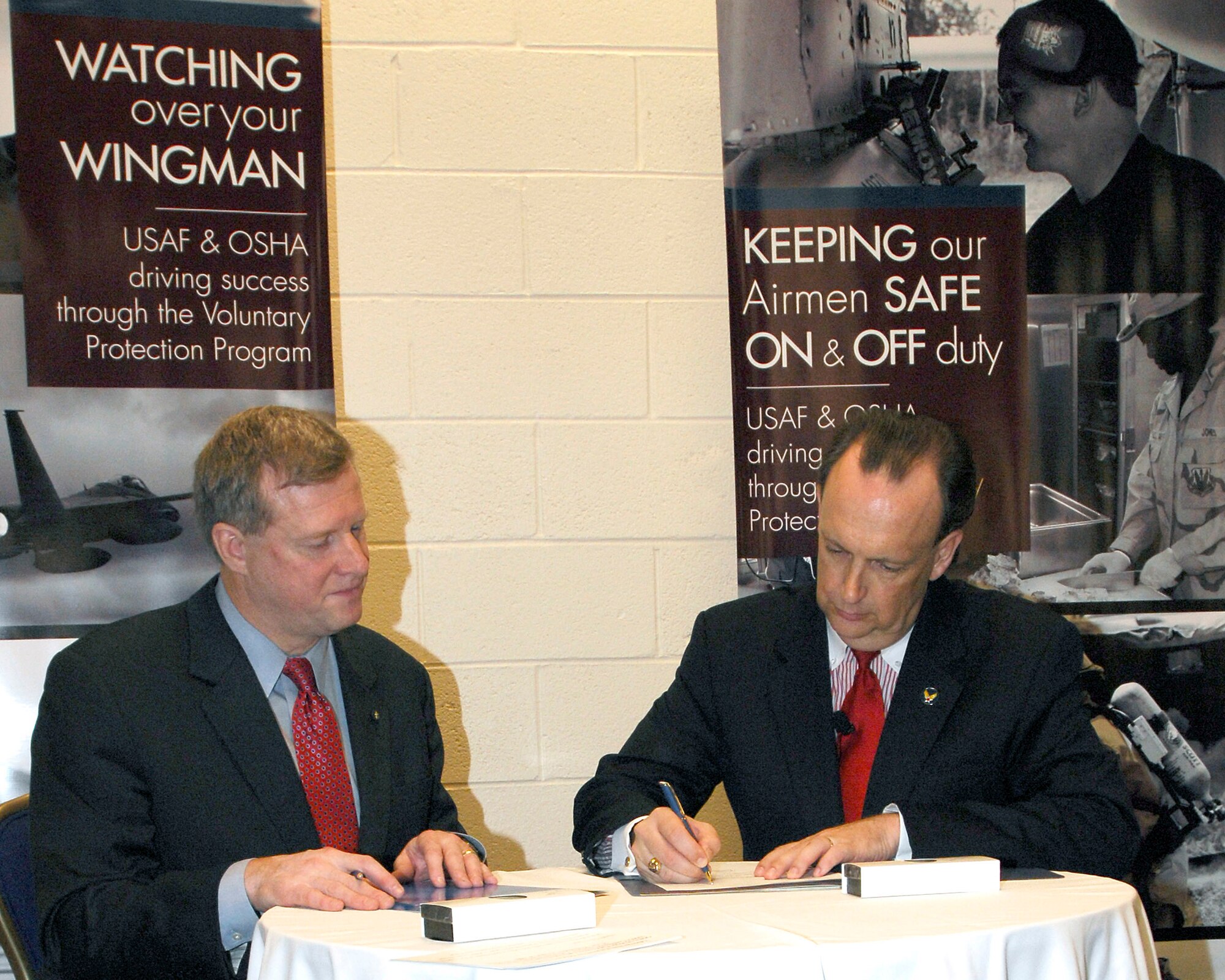 Edwin G. Foulke (left) and William C. Anderson sign a partnership agreement between the Air Force and Occupational Safety and Health Administration Aug. 27 in Washington, D.C. The agreement formalizes each organization's commitment to improve safety and health, and reduce injuries and illness within the Air Force through the Voluntary Protection Program. Mr. Foulke is the assistant secretary for Occupational Safety and Health, and Mr. Anderson is the assistant secretary of the Air Force for installations, environment and logistics. (U.S. Air Force photo/Michael Pausic) 
