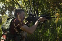 MINOT AIR FORCE BASE, N.D. -- Airman 1st Class Shawn Parkins, 5th Security Forces Squadron, simulates opening fire with his M4 rifle on a convoy during a force-on-force exercise here. A1C Parkins posed as an enemy combatant trying to attack a convoy. The exercise helps train security forces members how to react while taking fire from enemy forces. (U.S. Air Force photo by SrA Christopher Boitz) 
