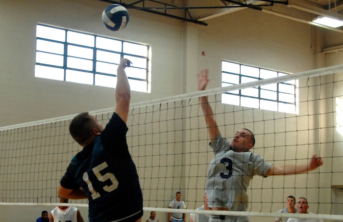 Brian Wright, CES, tips the ball over the net while Jake Viveiros, SFS, attempts to block the ball. (U.S. Air Force photo/Senior Airman Sam Hymas)
