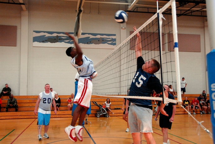 Brian Wright, CES, hits the ball over the nest while Michael Better, SFS, attempts to block. (U.S. Air Force photo/Senior Airman Sam Hymas)