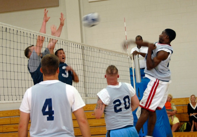 Michael Better, 437th Security Forces Squadron, spikes the ball into Eric Sifers and Shawn Lindsey of the 437th Civil Engineer Squadron Tuesday at the Fitness and Sports Center. CES won the match 25-18, 22-25, 15-13. (U.S. Air Force photo/Airman 1st Class Katie Gieratz)