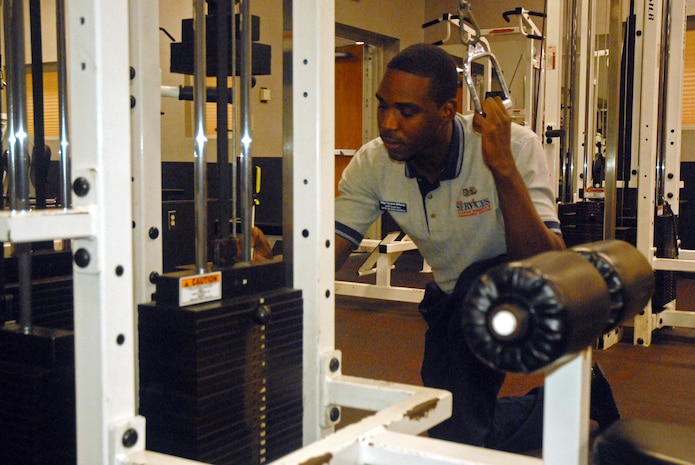 Staff Sgt. William Tavarus, 437th Services Squadron fitness specialist, inspects the rods on a cable crossover machine for rust corrosion Wednesday at the base Fitness and Sports Center.  The staff at the fitness center performs routine checks on fitness equipment to ensure safety for users. (U.S. Air Force photo/Airman Melissa White)
