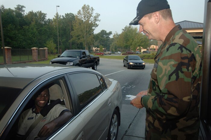 Col. John "Red" Millander, 437th Airlift Wing commander greets Staff Sgt. Amos Seymore, 437th Services Squadron Fitness and Sports Center NCO in charge of operations, and wishes him a safe Labor Day weekend at the base's main gate Aug. 30.  The commander and command chief greeted base members by the gate for about an hour that morning to let them know their value to Team Charleston.  No base fatalities were reported over the weekend. (U.S. Air Force photo/Staff Sgt. April Quintanilla) 
