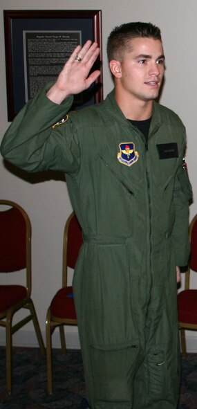 LAUGHLIN AIR FORCE BASE, Texas -- 2nd Lt. Chris Redmond the 85th Flying Training Squadron, raises his right and in order to swear his father Chief Master Sgt. Chris Redmond, command chief for Air Force Office of Special Investigations, in for another few years of the U.S. Air Force.