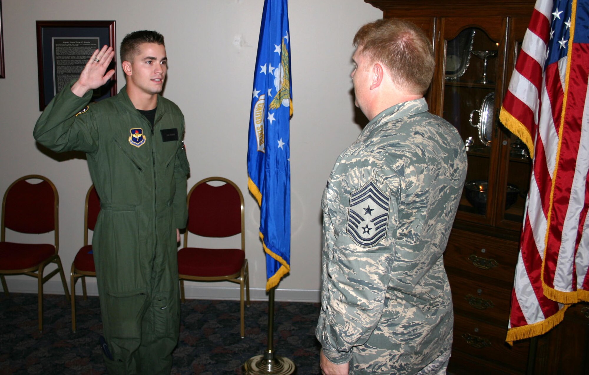 LAUGHLIN AIR FORCE BASE, Texas -- Chief Master Sgt. Chris Redmond, command chief for Air Force Office of Special Investigations, raises his hand and repeats after swear his oldest son, 24-year-old 2nd Lt. Chris Redmond the 85th Flying Training Squadron, recently.