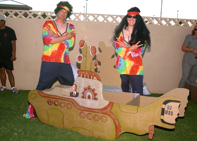 Tech. Sgt. Eric Champagne, a manpower and organization technician and team mate Capt. Tammy Schlichenmaier, military personnel flight commander, both with the 99th Mission Support Squadron show off their creation, “The Yellow Submarine” at the third annual Build-a-boat race at the Nellis Olympic Pool Aug. 29. The team took home the best decorated and the “golden rock” award at this year’s race.  (U.S, Air Force photo by Staff Sgt. Jacob R. McCarthy)                