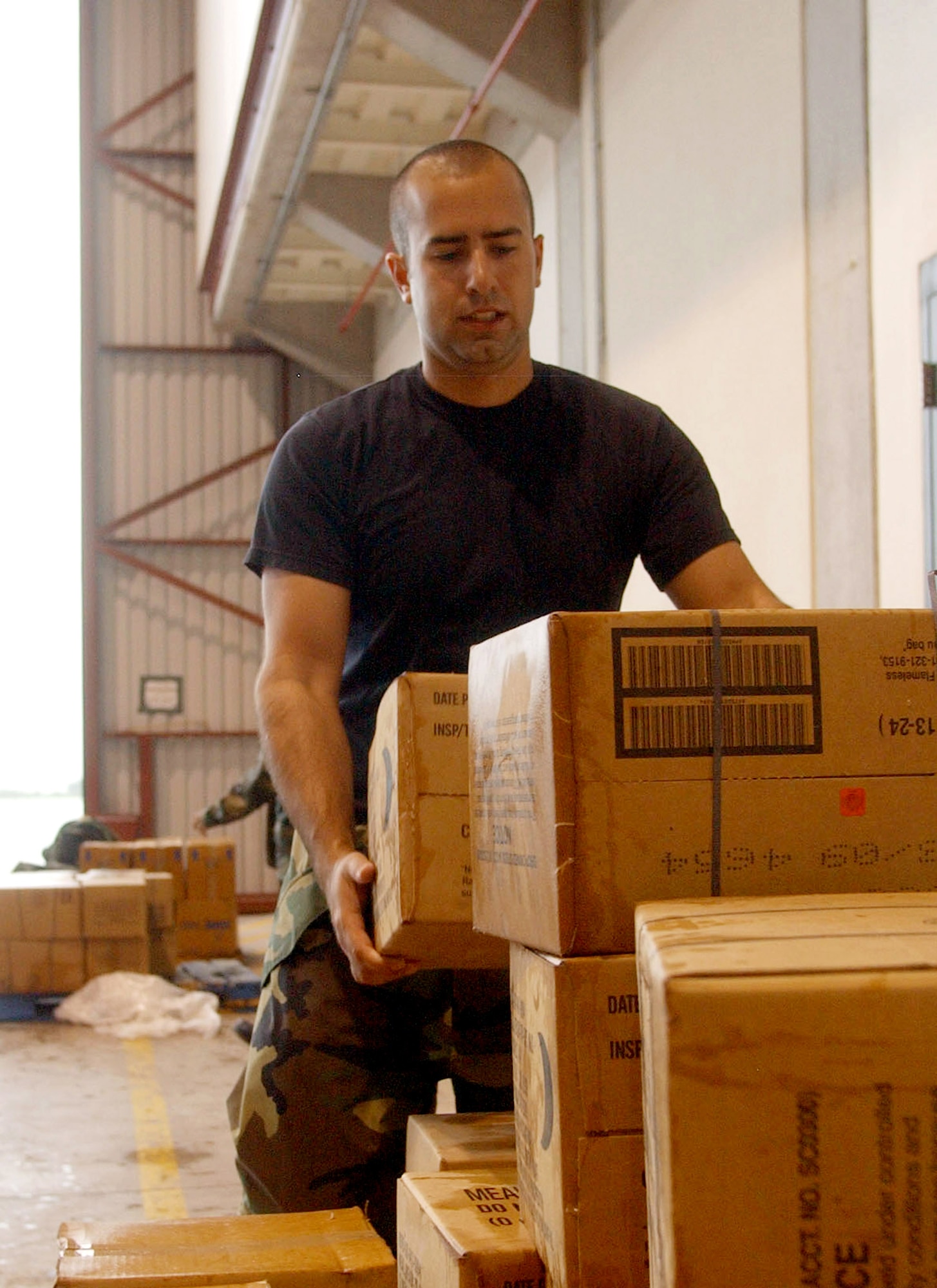 1st Lt. Juan Pablo Fiol stacks boxes of supplies to load onto aircaft Sept. 4 at Soto Cano Air Base, Honduras, in preparation for assessment teams to respond to aid requests following Hurricane Felix.  Lieutenant Fiol is a Joint Task Force-Bravo installation transportation officer. The assessment teams include multiple members to evaluate the amount of assistance needed from U.S. forces, including search and rescue, medical, engineering and communications troops. (U.S. Air Force photo/Martin Chahin)       