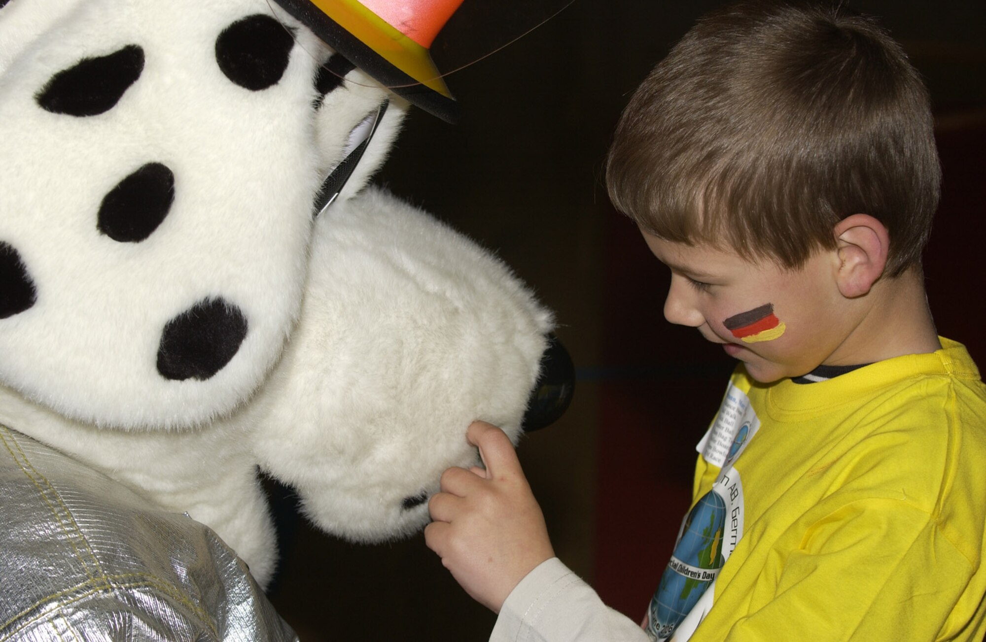 SPANGDAHLEM AIR BASE, Germany – Sparky the Firedog greets a child at the 2006 St. Martin’s Children’s Day event for special needs children from St. Martins School in Bitburg and local Department of Defense Dependents schools. The St. Martin’s Special Children’s Day committee needs 225 Sabers volunteers to assist with a full day of sporting events for local special needs students Sept. 20. (Courtesy photo)