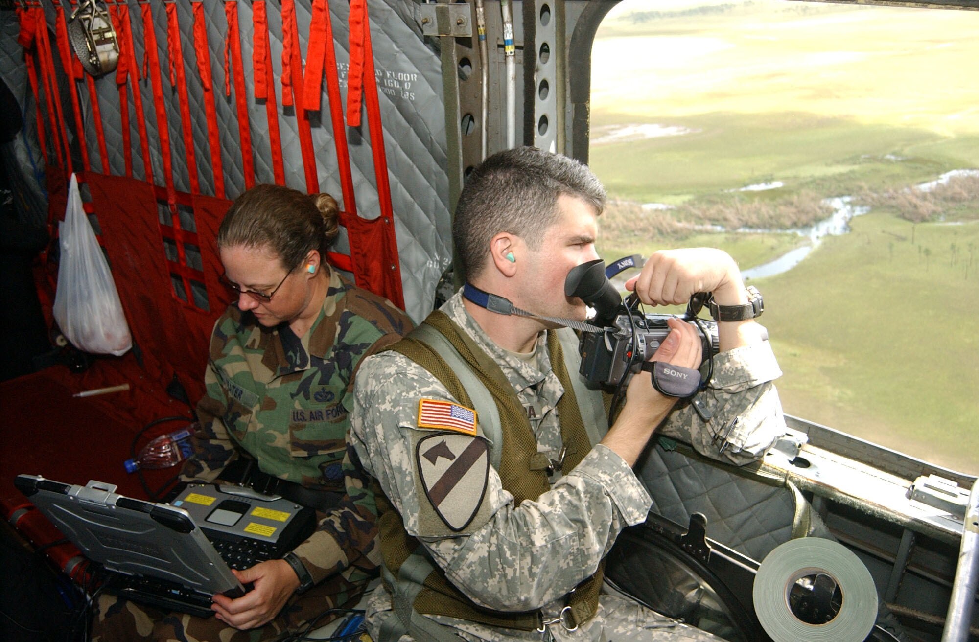 OVER THE MOSQUITO COAST, Nicaragua -- Army Capt. Jon-Paul Lavandeira and Tech. Sgt. Heather Prater, both engineers assigned to Joint Task Force Bravo at Soto Cano Air Base, Honduras, take aerial video from a CH-47 Chinook helicopter here to document damage caused by Hurricane Felix.  The two service members are part of a 13-person task force deployed here for hurricane damage assessment.  The video system is an Automated Route Recon Kit, or ARRK, which allows video, still images and global positioning system coordinates to be transmitted back to U.S. Southern Command, Joint Task Force Bravo, and the American Embassy in Nicaragua.  U.S. Air Force photo by Tech. Sgt. Sonny Cohrs                               