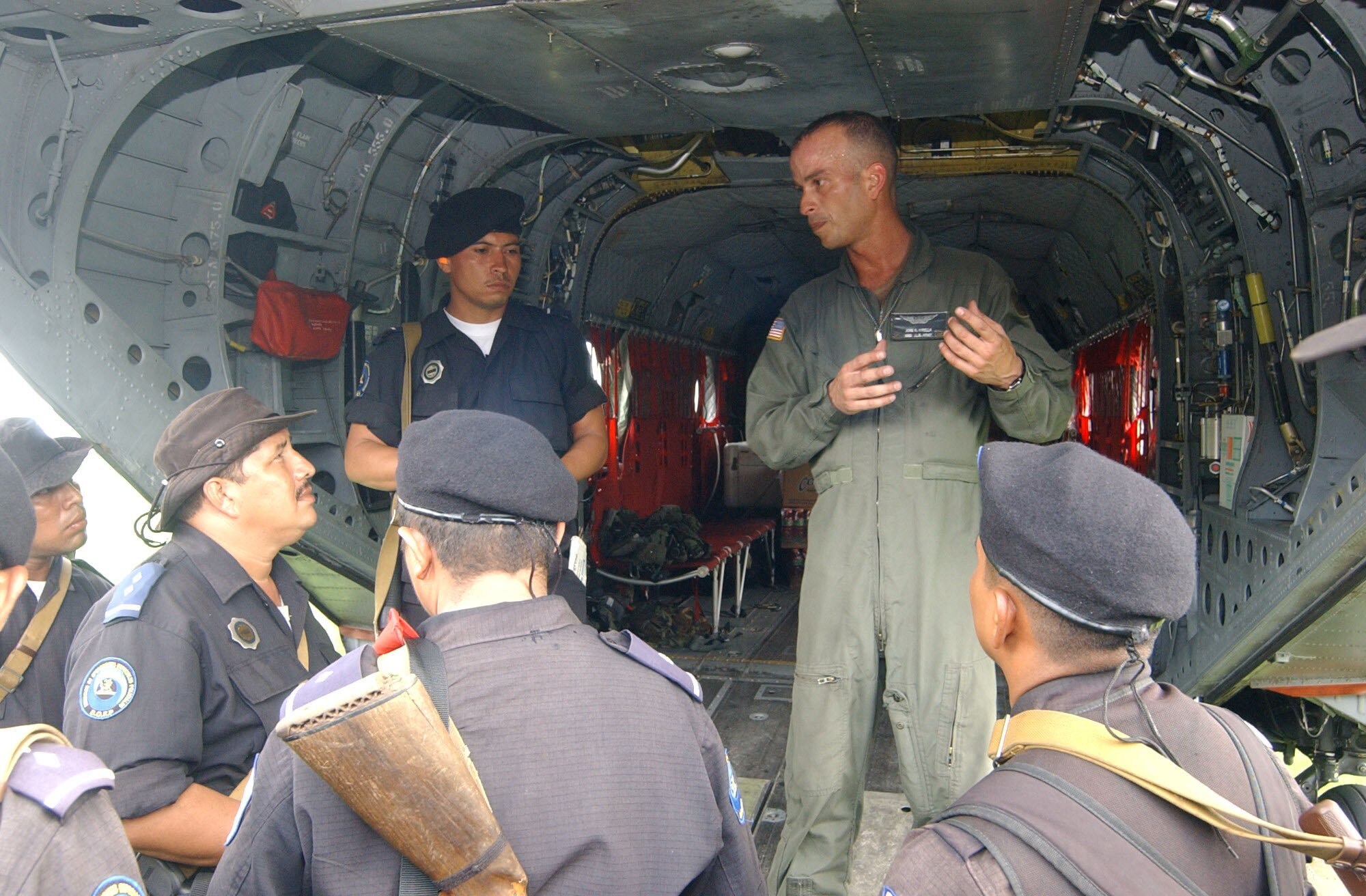MANAGUA, Nicaragua -- Army Staff Sgt. Jose Virella, assigned to the 1st Battalion, 228th Aviation Regiment at Soto Cano Air Base, Honduras, explains emergency aircraft procedures to members of the Nicaraguan National Police Special Brigade?s search and rescue team after landing here Sept. 5.  Sergeant Virella arrived with a hurricane assessment team following landfall of Hurricane Felix.  The 13-person team deployed to Nicaragua to assess the damage caused by the storm and to determine the extent of relief efforts needed in the country.  US Air Force photo by Tech. Sgt. Sonny Cohrs                               
