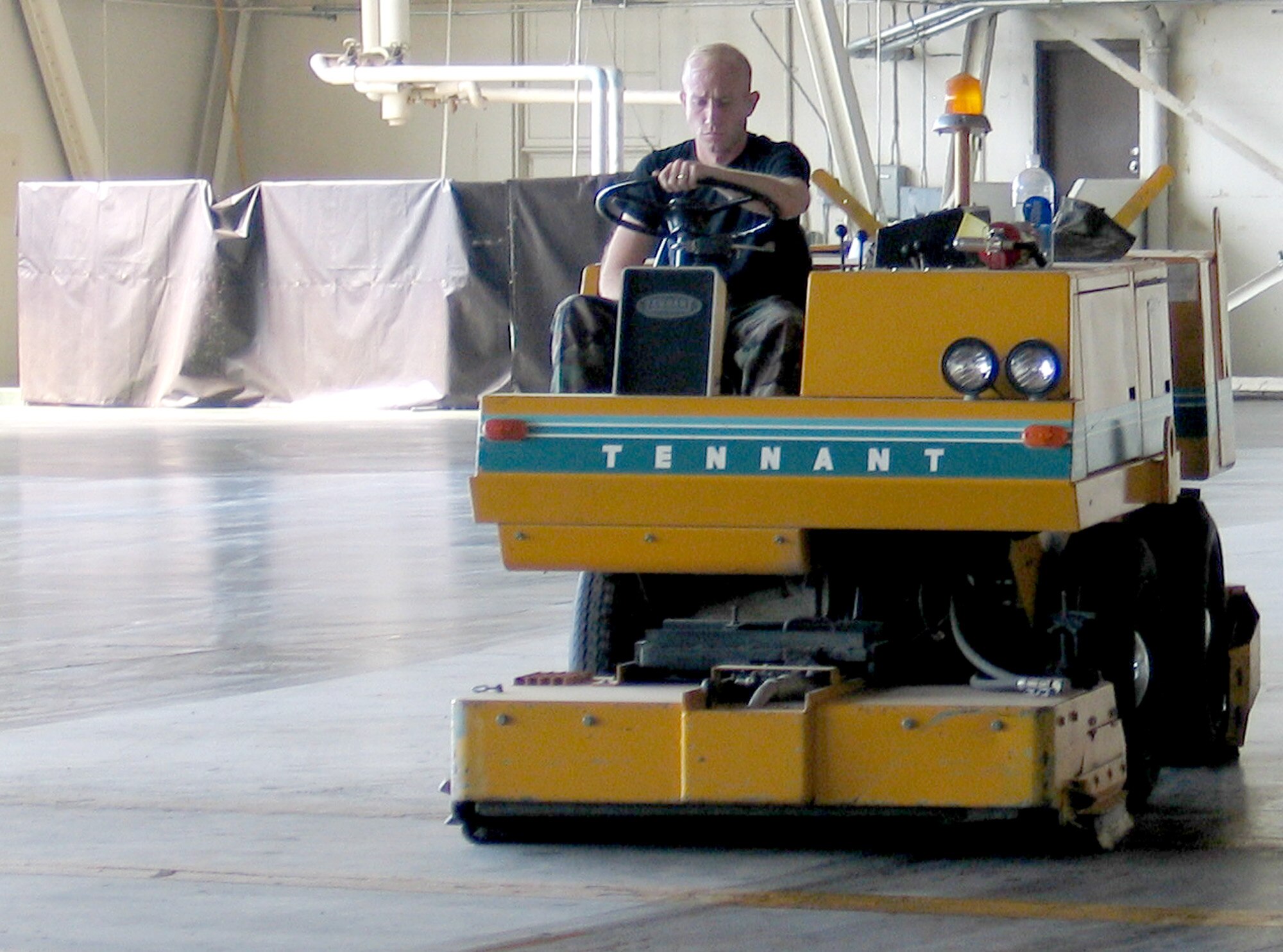 FAIRCHILD AIR FORCE BASE, Wash. – Staff Sgt. John Brown, 92nd Maintenance Operations Squadron, runs a floor scrubber across Hangar 2 here Sept. 5 in preparation for the Air Force 60th Anniversary Ball, scheduled for Sept. 8. Clean-up and decorations crews have been in and out of Hangars 2 and 4 all week preparing for the ball, and decorations volunteers will transform the Hangars into a formal scene Sept. 7. More than 700 Team Fairchild members are scheduled to attend the ball. (U.S. Air Force photo/Staff Sgt. Connie L. Bias)