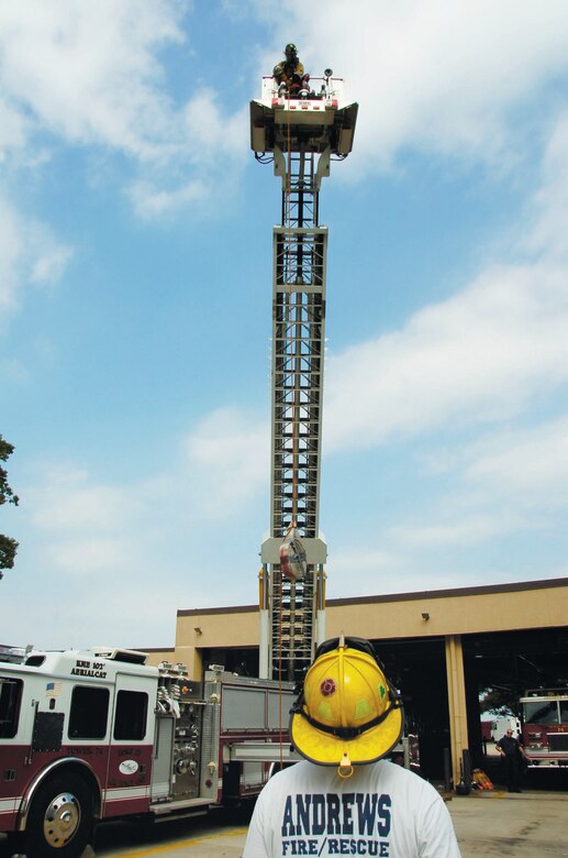 Adam Burak, 316 CES lead firefighter, holds a steady rope while watching a firefighter hoist a 50-pound fire hose hand-over-hand.  The purpose of the exercise is to test the strength and stamina of the firefighters to perform their job.