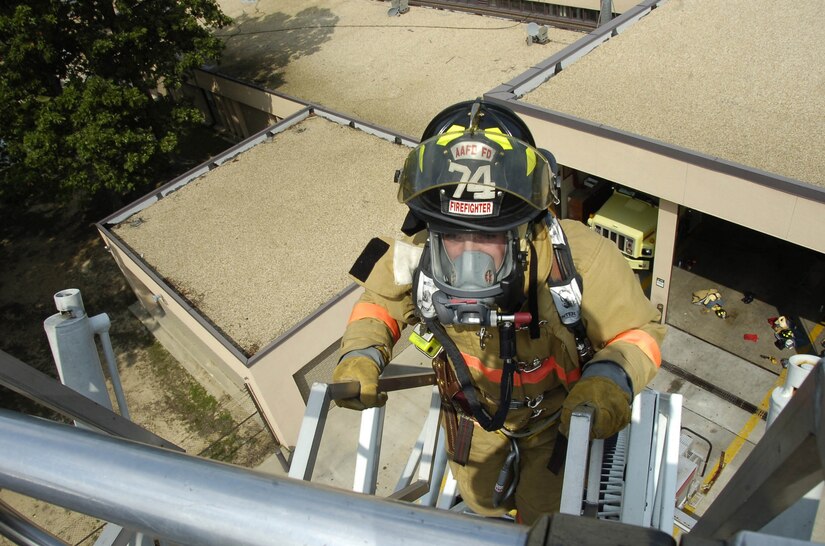 Airman Shane Stonesiffer ascends a 102-foot fire truck ladder during the stairwell climb portion of the training exercise.