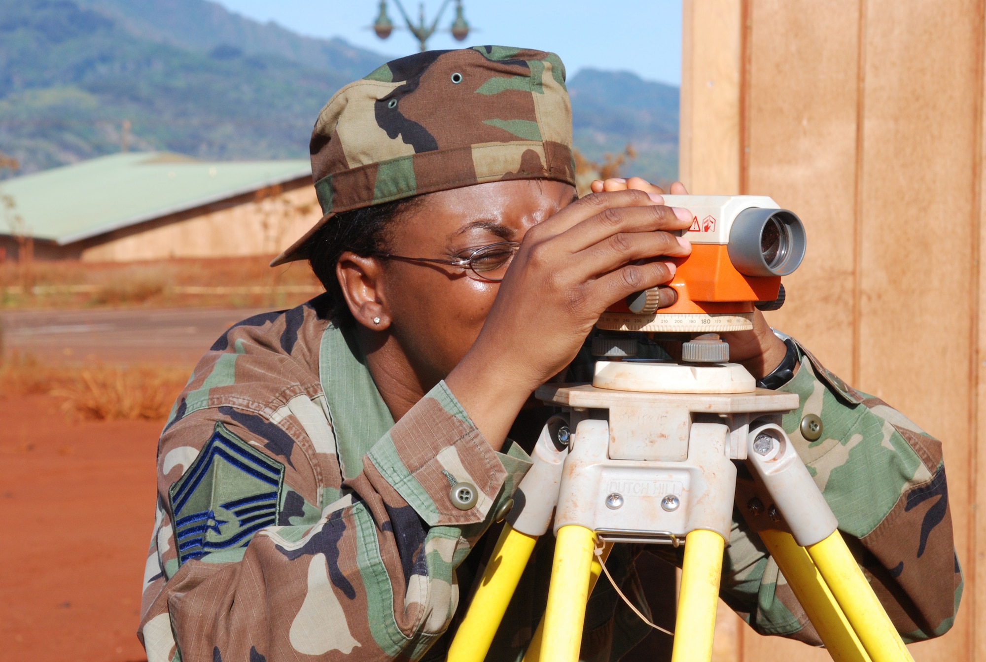 Senior Master Sgt. Darlies Howard, 301st Civil Engineer Squadron Naval Air Station Joint Reserve Base Fort Worth, Texas, engineering craftsman, performs a site survey for remaining cabin construction. The 36-member team worked on this Innovative Readiness Training project at the Helemano Plantation in Oahu, Hawaii., for two weeks performing concrete foundation construction; framing; commercial/residential electrical work; entomology; supply; and surveying to name a few areas. 