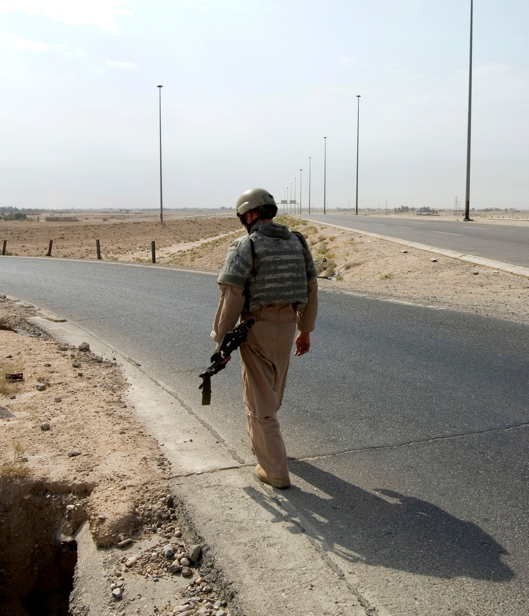 Staff Sgt. Charles Lemley searches for improvised explosive devices at an intersection on a convoy route in August in southern Iraq. Sergeant Lemley is assigned to the 887th Expeditionary Security Forces Squadron. (U.S. Air Force photo/Senior Airman Andrew Dumboski)
