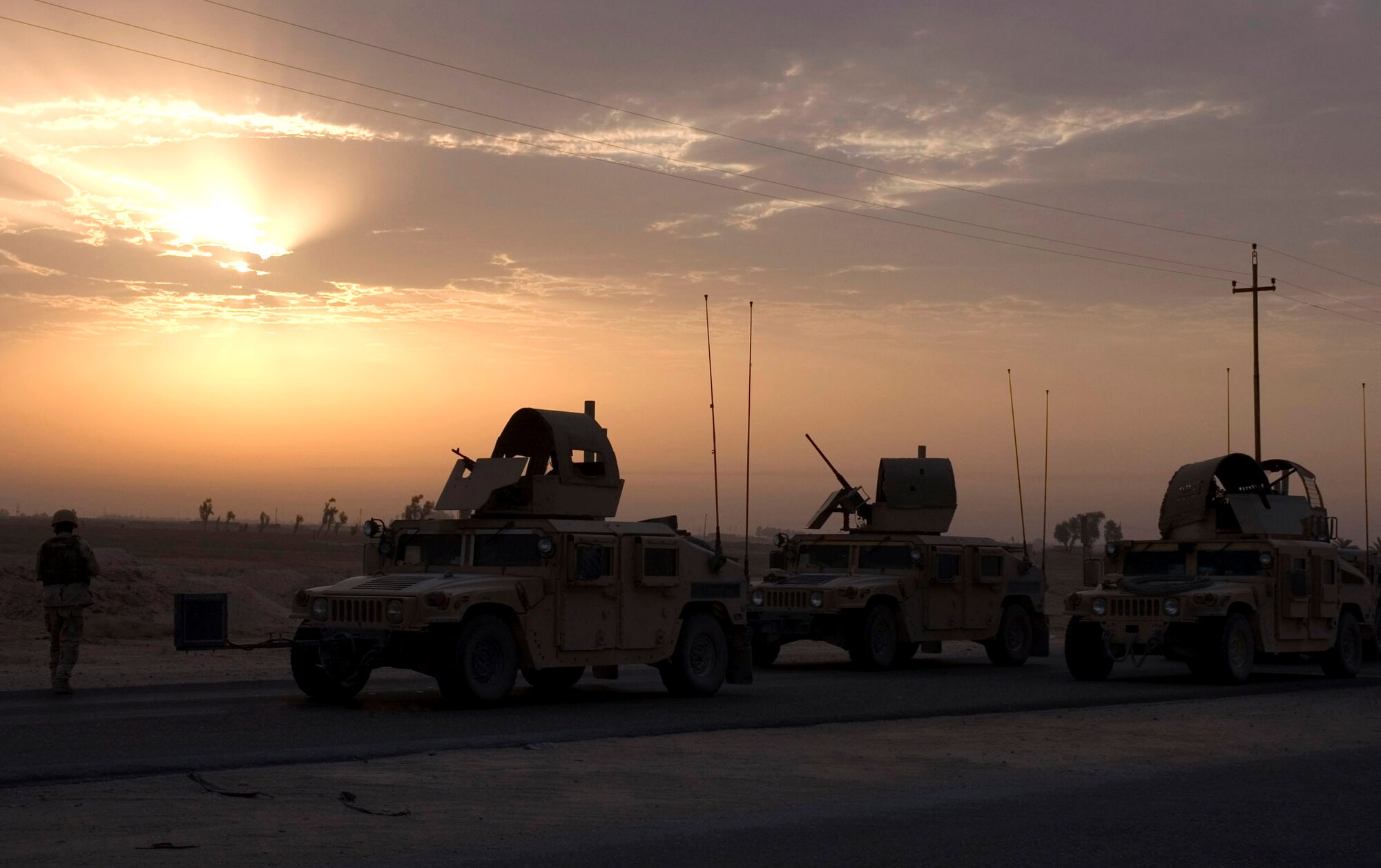 Humvees from the 887th Expeditionary Security Forces Squadron slowly follow behind members of the 887th ESFS during a patrol in August in southern Iraq. Members of the 887th ESFS patrol convoy routes to keep them clear of improvised explosive devices. (U.S. Air Force photo/Staff Sgt. Raymond Mills) 
