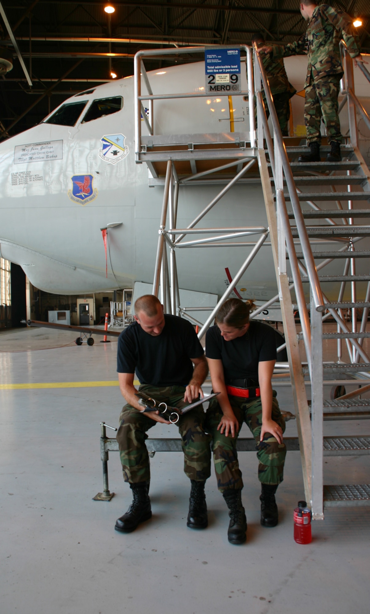 E-3 Sentry crew chief Tech. Sgt. Matthew Bishop, 513th Aircraft Maintenance Squadron, conducts on-the-job technical order training with E-3 crew chief-in-training Airman 1st Class Brandi Garris, 552nd Aircraft Maintenance Squadron, before going onto the E-3 for hands-on training.  Airmen in the AMXS deploy with their designated operational units around the world to ensure the E-3 is mission ready. (Photo by Staff Sgt. Stacy Fowler)