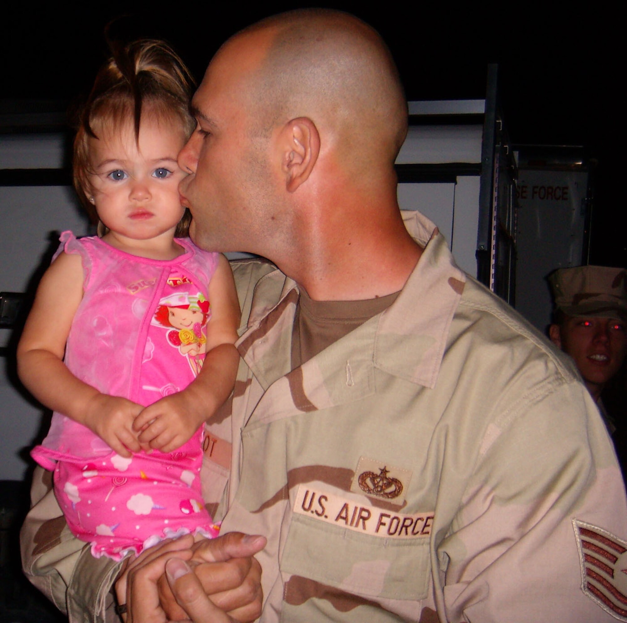Tech. Sgt. Shawn Elliot, 49th Civil Engineer Squadron, kisses his daughter goodbye before hopping on an airplane to Southwest Asia. More than 35 Holloman Airmen leave early Sept. 6 for a deployment in support of the War on Terror. These Airmen are a part of approximately 700 Airmen deploying in the upcoming Air and Space Expeditionary cycle. (U.S. Air Force photo/Airman 1st Class Heather Stanton)