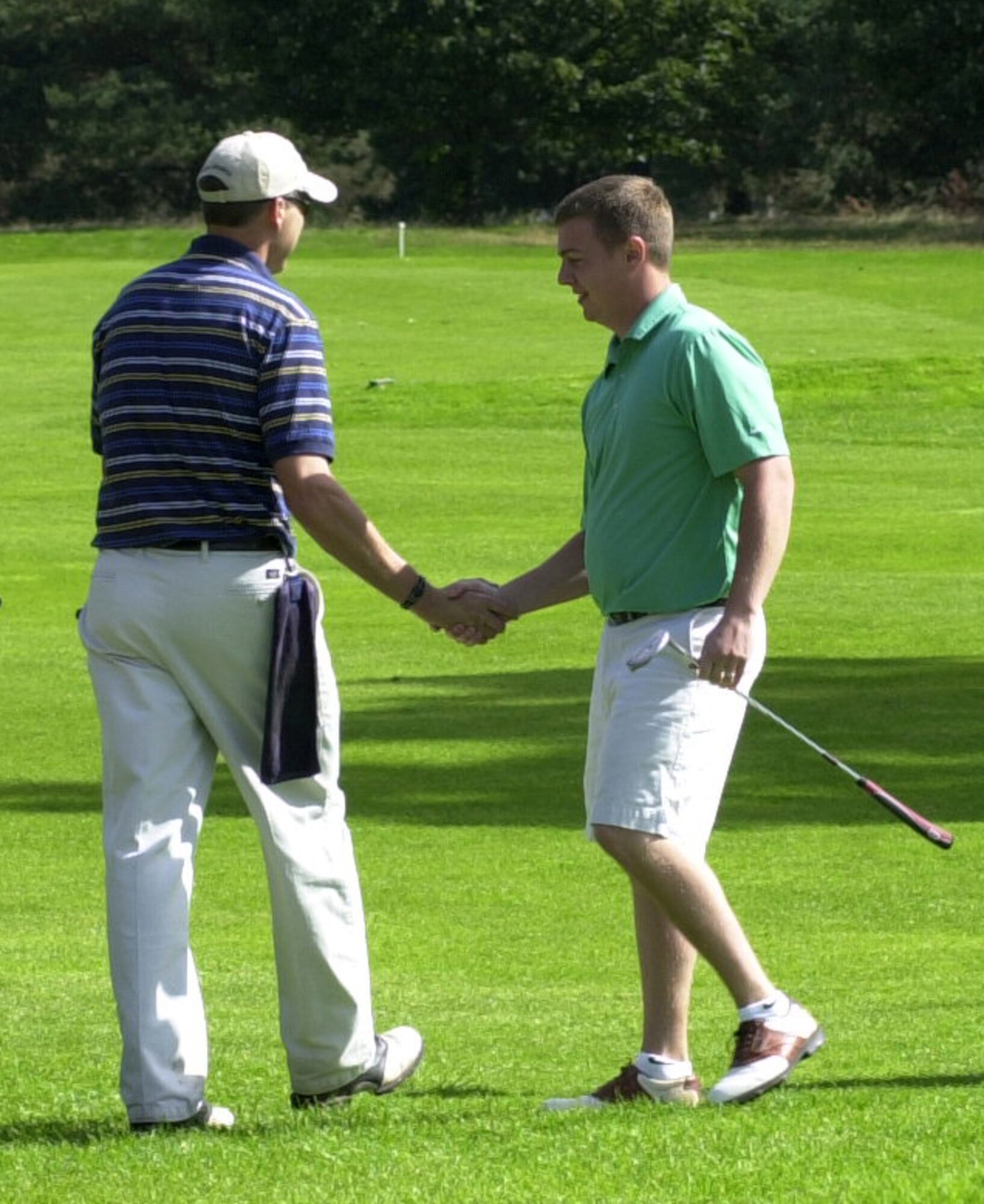 Rob Marchewka, a 352nd Maintenance Squadron member, congratulates the 100th Logistics Readiness Squadron player Andy Hunn, on the 18th green after the 100th LRS defeated the 352nd MXS 12-0 in the RAF Mildenhall intramural golf championship held at Breckland Pines, Sept. 4. (U.S. Air Force photo by Gary Rogers)