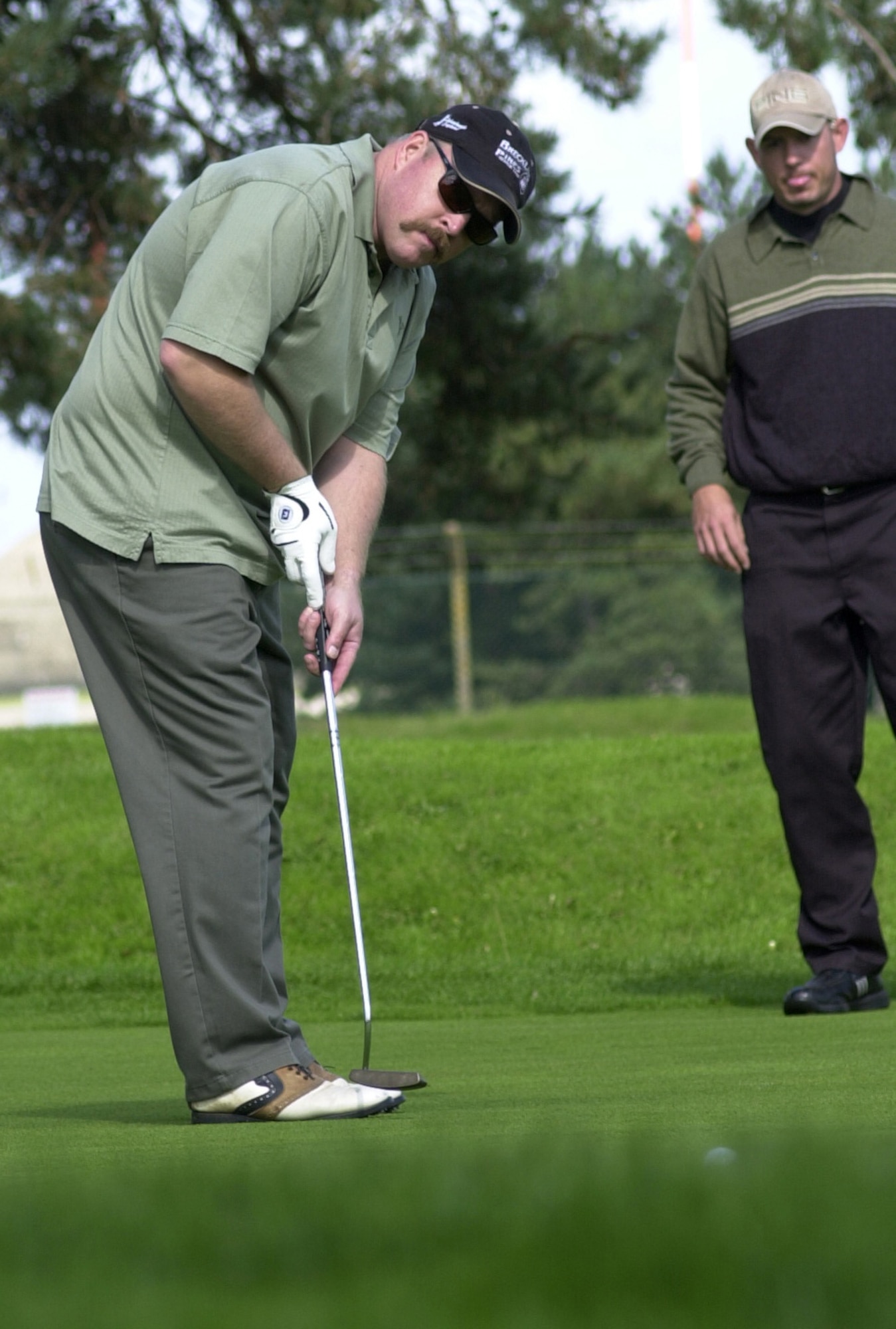 Nathan Hedstrom, putting, and his playing partner Stephan Boczar, members of the 352nd Maintenance Squadron, both follow the line of Hedstrom’s putt on the 16th green during the intramural golf championship at Breckland Pines Golf Club, Sept. 4. (U.S. Air Force photo by Gary Rogers)