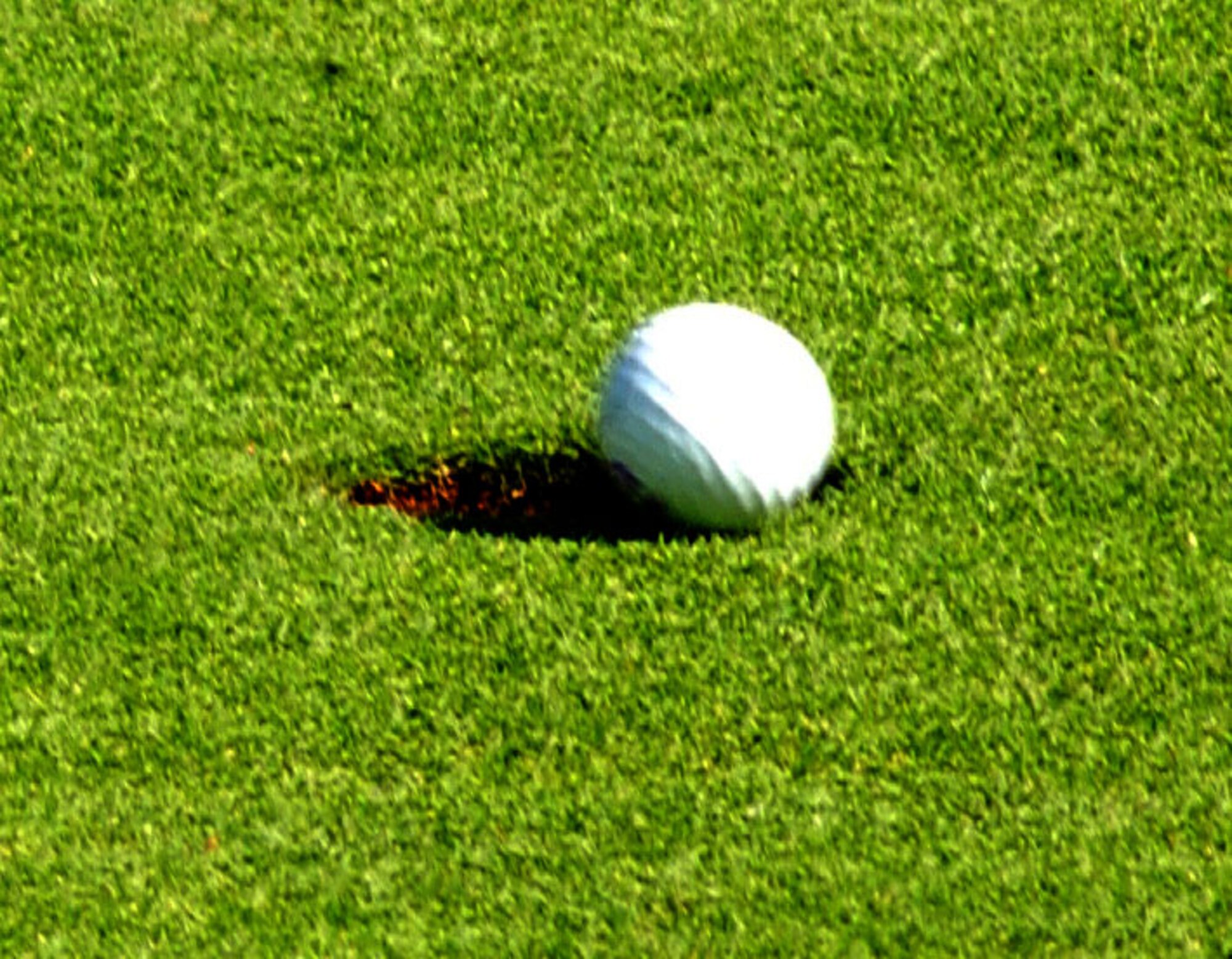 The ball drops into the hole during the two-man scramble intramural golf championship held at Breckland Pines Golf Club, RAF Lakenheath. This is the first time this two-man scramble format has been use in intramural golf, and has so far been very popular with the players. In a scramble, each player tees off on each hole. The best of the tee shots is then selected and all players play their second shots from that spot. The best of the second shots is determined, and then all play their third shots from that spot, and so on until the ball is holed. (U.S. Air Force photo by Airman Brad Smith)