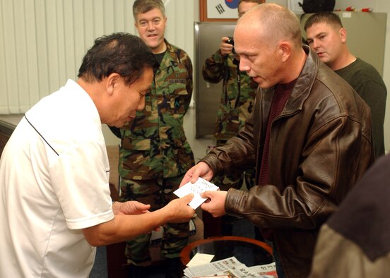 GUNSAN CITY, Republic of Korea -- Master Sgt. William Highlander, 8th Logistics Readiness Squadron Distribution NCO in charge, presents 450-thousand Won to David Kim at the Gunsan Orphanage here Sept. 5. Sergeant Highlander and 12 other Airmen from the 8th Logistics Readiness Squadron volunteered at the Kunsan Air Base Commissary here to raise money for the children at the Gunsan Orphanage as part of a Good Neighbor Program initiative. (U.S. Air Force photo/Senior Airman Steven R. Doty) 