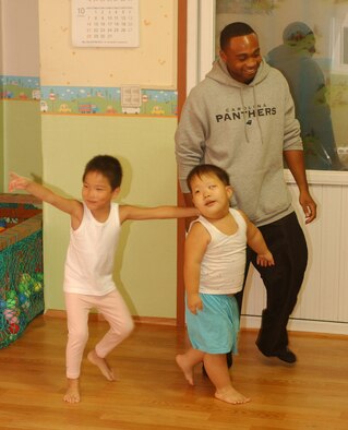GUNSAN CITY, Republic of Korea -- Senior Airman Gary Mallard, 8th Logistics Readiness Squadron, plays with children at the Gunsan Orphanage here Sept. 5. The 8th Logistics Readiness Squadron volunteered at the Kunsan Air Base Commissary to raise money for the children at the Gunsan Orphanage as part of a Good Neighbor Program initiative. After presenting the money, they spent time with the children. (U.S. Air Force photo / Senior Airman Steven R. Doty) 