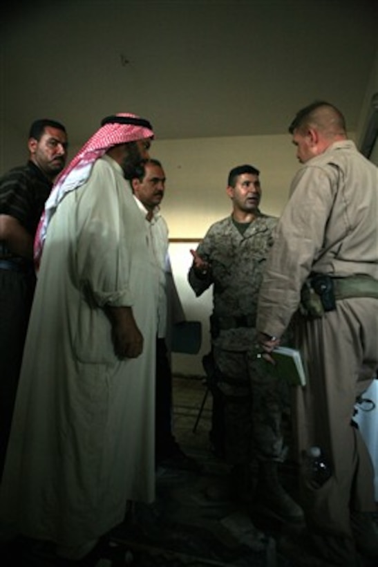 An interpreter (center) translates for Chief Warrant Officer Steven Townsley, U.S. Marine Corps, as he talks with the local town leaders after a meeting in Fallujah, Iraq, on Aug. 24, 2007.  Townsley is attached to the 5th Battalion, 10th Marines Civil Affairs Group.  