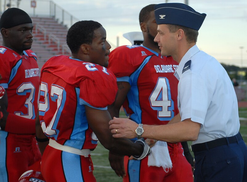 Col. Steve Harrison, 436th Airlift Wing commander, offers hand shakes and a round of 'good luck' to the Delaware State University Hornet football team. Colonel Harrison also tossed a ceremonial coin to open the game and represent Dover Air Force Base for DSU's Military Appreciation Night Saturday. (U.S. Air Force photo/Tech. Sgt. Kevin Wallace)
